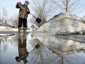 OTTAWA - March 11, 2021 Carl Ward removes some ice and snow at the end of his driveway on Lemay Crescent in Ottawa Thursday.