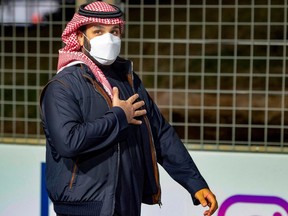 In this handout picture provided by the Saudi Royal Palace, Saudi Arabian Crown Prince Mohammed bin Salman greets the public as he attends the Round 2: Diriyah E-Prix, in the Saudi capital Riyadh, on February 27, 2021.