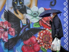 FILE:A man walks in the rain.