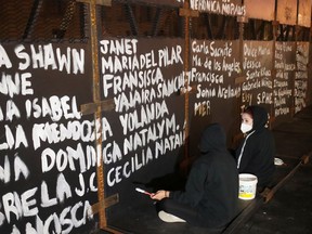 Women paint the names of victims of femicide in Mexico on fences placed outside the National Palace ahead of a Women's Day protest, in Mexico City , Mexico March 6, 2021.