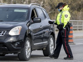 Ottawa Police screen travellers crossing the Chaudiere Bridge from Quebec into Ontario on Tuesday. They've scaled back such operations since the start of the week.