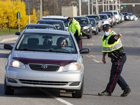 Ottawa police officers screen travellers entering Ontario from Quebec on the Champlain Bridge Monday. Police checks have eased up since then.