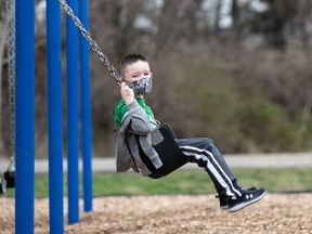 FILE: A child uses a swingset.