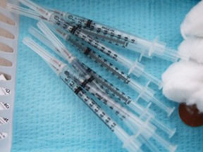 FILE: Syringes containing a dose of the Pfizer COVID-19 vaccine.