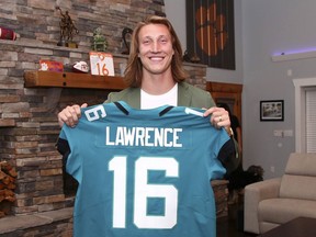 A handout photo provided by the National Football League, quarterback shows Trevor Lawrence with a Jacksonville Jaguars jersey after they made him the No. 1 pick in the draft on Thursday night.