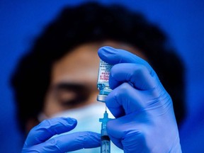 In this file photo taken on February 16, 2021 medical worker Robert Gilbertson loads a syringe with the Moderna Covid-19 vaccine to be administered by nurses at a vaccination site at Kedren Community Health Center, in South Central Los Angeles, California.