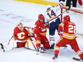 The Calgary Flames try to clear the puck while the Edmonton Oilers attack the net at the Scotiabank Saddledome in Calgary on Saturday, April 10, 2021.