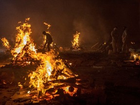 People cremate the bodies of victims of the COVID-19 at a crematorium ground in New Delhi, India on April 24.