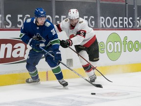 Ottawa Senators defenceman Mike Reilly checks Vancouver Canucks forward Nils Hoglander in the first period at Rogers Arena, Jan. 28, 2021.