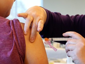 Brianna Grant receives a vaccine from Renée Larocque during an Ottawa Public Health catch up vaccination clinic, March 11, 2015.   (Jean Levac/ Ottawa Citizen)