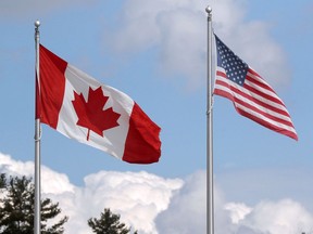 FILE PHOTO: A U.S. and a Canadian flag flutter at the Canada-United States border crossing.