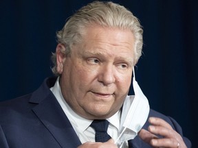 Ontario Premier Doug Ford takes off his mask during an April 1, 2021 announcement at Queen's Park. Ontario will enter into a four-week partial shutdown beginning Saturday as COVID-19 cases in the province spike. Frank Gunn/The Canadian Press