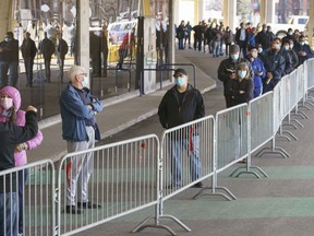 People wait in line at a COVID-19 vaccination clinic to receive the AstraZeneca vaccine at Olympic Stadium in Montreal, on Thursday, April 8, 2021.