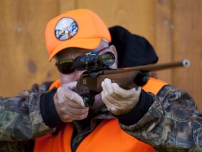 An Ontario rifle owner checks the sight of his rifle at a hunting camp.