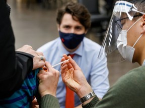 FILE: Canada's Prime Minister Justin Trudeau watches as nurse Thi Nguyen gives a COVID-19 vaccination at a clinic, as efforts continue to help slow the spread of the coronavirus disease, in Ottawa, Ontario, Canada March 30, 2021.