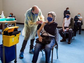 A nurse administers the Pfizer/BioNTech COVID-19 vaccine in Toronto. How would mandatory vaccination work?