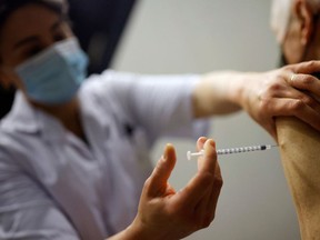 A healthcare worker administers a dose of tPfizer BioNTech COVID-19 vaccine