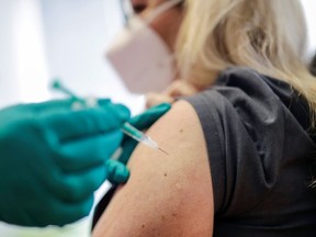 A woman receives a dose of the Pfizer-BioNTech coronavirus disease (COVID-19) vaccine.