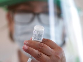 FILE: A medical worker prepares a dose COVID-19 vaccine.