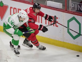 Toronto Maple Leafs left wing Jimmy Vessey (left) battles with Ottawa Senators defenceman Erik Gudbranson for control of the puck in the third period at the Canadian Tire Centre, March 14, 2021.