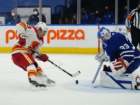 Apr 13, 2021; Toronto, Ontario, CAN; Calgary Flames forward Johnny Gaudreau (13) dekes around Toronto Maple Leafs goaltender David Rittich (33) to score the winning goal in overtime at Scotiabank Arena.