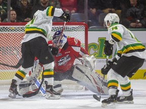 Knight's Nathan Dunkley gets in too tight on Windsor's Kari Piiroinen as Luke Evangelista comes into to help but they can't dig the puck out of Piiroinen's pads during the first period of their OHL game Friday night at Budweiser Gardens in London, Ont.  Photograph taken on Friday November 29, 2019.
