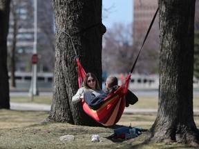 OTTAWA - April 7, 2021 - Emmas Watts and Jason Belaire relax in a hammock near Dow's Lake in Ottawa Wednesday.