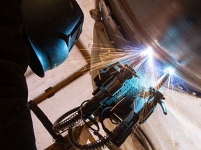 FILE: A worker welds a section of pipe.