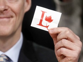 Files:  A man holds up a Liberal Party logo.