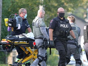 Police and paramedics remove a man from a home on Ford Street after Kingston Police responded to a scene  after a man allegedly stabbed three people and barricaded himself in the home on Wednesday September 23, 2020.