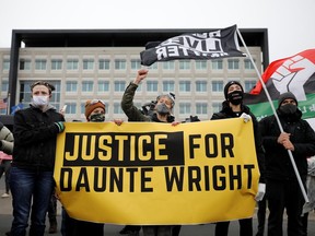 Demonstrators hold a banner in front of the FBI Minneapolis Division building as they march days after Daunte Wright, 20, was shot and killed by former Brooklyn Center Police Officer Kim Potter, in Brooklyn Center, Minnesota, U.S., April 13, 2021.