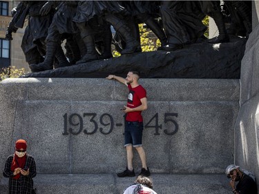 Crowds police estimated at 3,000 marched in downtown Ottawa Saturday to protest the continuing violence in East Jerusalem Saturday, May 15, 2021. A protestor stood on the side of the War Memorial during the march.