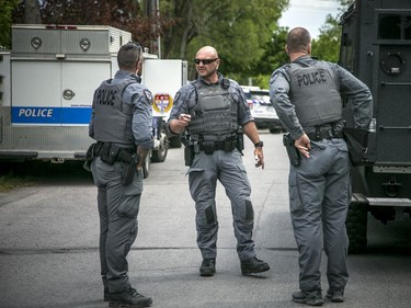 Ottawa police had numerous officers from multiple units at a housing complex on Hochelaga Street, Sunday, May 16, 2021. Ottawa police tactical members loaded the armoured vehicle with firearms and protective gear before driving into the area of the incident.
