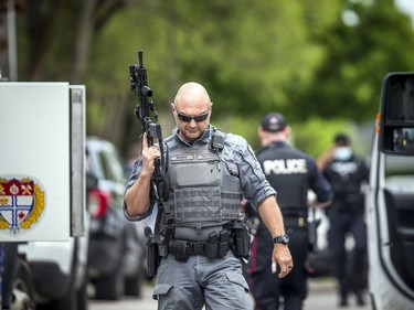 Ottawa police had numerous officers from multiple units at a housing complex on Hochelaga Street, Sunday, May 16, 2021. Ottawa police tactical members loaded the armoured vehicle with firearms and protective gear before driving into the area of the incident.
