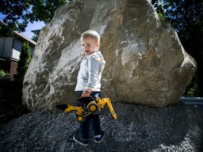 A massive boulder was dug up during construction on Bellwood Avenue. Two-year-old George Nashef was excited to play beside it on Saturday, but he'll need a bigger backhoe if he's going to help move it.