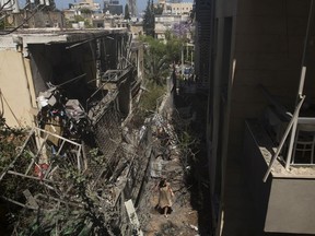 A Woman walks at the scene where a rocket launced from the Gaza strip hit her house on May 12, 2021 in Giv'atayim, Israel. At least three dozen Palestinians and five Israelis have been killed in the cross-border exchange of rockets and aerial bombardment, which followed a series of violent and Palestinian protesters in East Jerusalem.