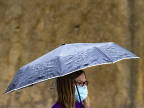 OTTAWA -- A woman walks in the rain along Elgin Street on Friday, Apr. 30, 2021 -- . ERROL MCGIHON, Postmedia