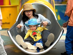This file photo taken on May 11, 2021 shows a mother and her baby playing on a slide