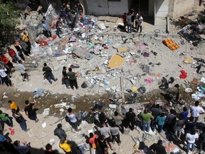 Palestinians gather at the scene where a house was hit by an Israeli air strike, amid a flare-up of Israeli-Palestinian violence, in the southern Gaza Strip May 12, 2021.