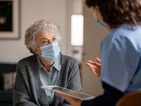 Doctor home visit a senior woman during the covid-19 pandemic
