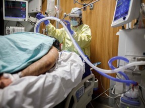 Respiratory Therapist Flor Guevara adjusts a breathing tube for a patient suffering from COVID-19 at an intensive care unit in Toronto.