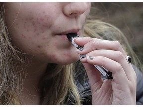 A high school student uses a vaping device. It's time for governments to take more action against big tobacco.