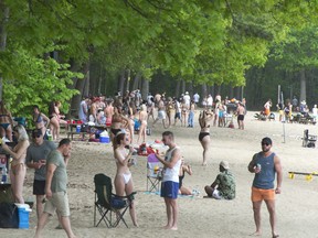 People enjoy the warm weather at the beach in Oka Provincial Park  Thursday, May 20, 2021  in Oka, Quebec. The park has limited access after crowds swarmed the beach in the past few days to escape the heat.