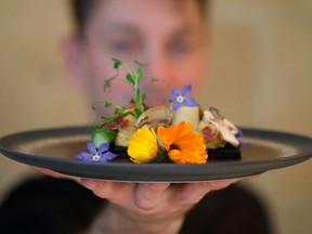 French chef Laurent Veyet displays a dish as he poses in his restaurant Inoveat serving insect-based food in Paris, France, May 12, 2021. Picture take May 12, 2021.