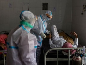 Medics tend to a man with breathing problems inside a COVID-19 ward of a government-run hospital, amidst the coronavirus disease (COVID-19) pandemic, in Bijnor district, Uttar Pradesh, India, May 11, 2021.