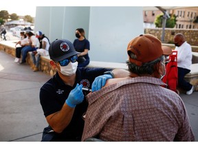 A health-care worker from the El Paso Fire Department administers the Moderna vaccine at a vaccination centre in El Paso, Texas.
