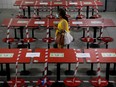 A woman walks between rows of taped up tables at a food centre as dining-in is restricted to curb the coronavirus disease (COVID-19) outbreak in Singapore May 17, 2021.   REUTERS/Edgar Su