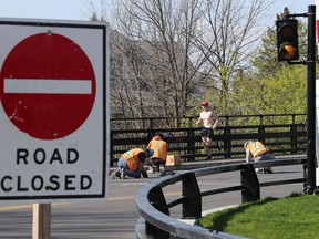 Construction crews work on the closed Hog's Back swing bridge in Ottawa Monday.