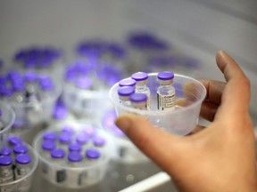 A nurse takes vials of Comirnaty vaccine by Pfizer-BioNTech against Covid-19 out of a fridge at the Baleone vaccine centre in Ajaccio on the French Mediterranean island of Corsica, on May 13, 2021.