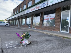 Neighbours left a memorial of plastic flowers and a stuffed bunny in the parking lot of a strip mall in the east end of Ottawa where 27-year-old Warsama Youssouf was gunned down in the early hours of Sunday, May 30, 2021.